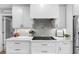 Modern kitchen features white cabinets, gray tile backsplash, and gas cooktop at 3756 E Lake Dr, Land O Lakes, FL 34639