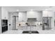 Modern kitchen with white cabinets, quartz countertops, and a stainless steel sink at 3756 E Lake Dr, Land O Lakes, FL 34639