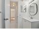 Clean bathroom with a white vanity, round mirror, and tub shower combo at 4233 Oakfield Ave, Holiday, FL 34691