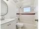 Clean bathroom with white vanity, tub, and maroon tile at 4233 Oakfield Ave, Holiday, FL 34691