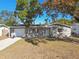 Charming ranch home with a gray exterior, white door, and attached garage at 4233 Oakfield Ave, Holiday, FL 34691