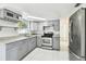 Modern kitchen with gray cabinets, granite countertops, and stainless steel appliances at 4233 Oakfield Ave, Holiday, FL 34691