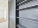 Gray pantry with built-in shelves and louvered sliding door at 4233 Oakfield Ave, Holiday, FL 34691