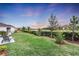 Spacious backyard with a pond view, lush landscaping, and a privacy fence at 5225 Caserta Ct, Palmetto, FL 34221