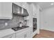 Modern kitchen features gas cooktop, stainless steel vent hood, and gray tile backsplash at 5225 Caserta Ct, Palmetto, FL 34221