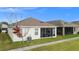 Rear view of house showing lanai, landscaping, and AC unit at 5725 Stockport St, Riverview, FL 33578