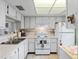 Efficient kitchen featuring white cabinets, tile backsplash, and standard appliances at 601 N Hercules Ave # 503, Clearwater, FL 33765