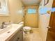 Cozy bathroom featuring a tiled shower, vanity with sink, and a toilet at 6700 Turner N St, St Petersburg, FL 33702