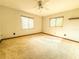 Bright bedroom with plush carpet, two windows, a ceiling fan, and minimalist decor at 6700 Turner N St, St Petersburg, FL 33702