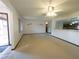 Bright living room featuring neutral carpet, white walls, ceiling fan, and a view of the kitchen at 6700 Turner N St, St Petersburg, FL 33702