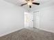 Bedroom with ceiling fan, neutral walls, gray carpeting, and a view of another room at 718 34Th S Ave, St Petersburg, FL 33705