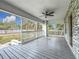 Spacious front porch with grey decking, white railings, and ceiling fan at 718 34Th S Ave, St Petersburg, FL 33705