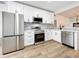 Modern kitchen features white cabinets, stainless steel appliances, and light wood floors at 718 34Th S Ave, St Petersburg, FL 33705