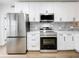 Modern kitchen with stainless steel appliances and white cabinets at 718 34Th S Ave, St Petersburg, FL 33705