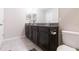 Double vanity bathroom with dark brown cabinets at 7236 Grand Elm Dr, Riverview, FL 33578