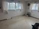Empty bedroom in disrepair with laminate floors, white walls, and natural light at 7800 3Rd S Ave, St Petersburg, FL 33707
