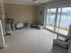 Unfurnished sunroom with tile floors, neutral walls, large windows, and sliding glass door to the water at 7800 3Rd S Ave, St Petersburg, FL 33707