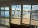 Waterfront view of dock through a large window with sliding doors in a room in need of repair at 7800 3Rd S Ave, St Petersburg, FL 33707