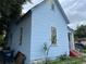 Side view of a light blue house with red steps and a small yard at 1209 E Dr Martin Luther King Jr Blvd, Tampa, FL 33603