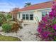Landscaped backyard with gravel, flowers, and a home at 1209 Peridot Ln, Sun City Center, FL 33573