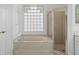 Bathroom with shower, bathtub, and a large window at 1209 Peridot Ln, Sun City Center, FL 33573