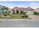House with a red tile roof, palm trees, and a landscaped lawn at 1209 Peridot Ln, Sun City Center, FL 33573