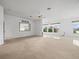 Large living room with beige carpet, ceiling fan, and mirror at 1209 Peridot Ln, Sun City Center, FL 33573