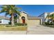 House exterior featuring a two-car garage and palm trees at 12410 Ballentrae Forest Dr, Riverview, FL 33579