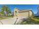 Tan house exterior with a red door and two-car garage at 12410 Ballentrae Forest Dr, Riverview, FL 33579