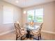 Small dining area with glass table and four chairs near kitchen at 19510 Whispering Brook Dr, Tampa, FL 33647