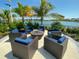 Relaxing outdoor fire pit area with wicker seating, overlooking a lake at 20249 Symphony Pl, Venice, FL 34293