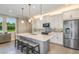 Modern kitchen with white cabinets, gray island, and stainless steel appliances at 20249 Symphony Pl, Venice, FL 34293