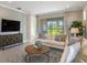 Relaxing living room with sectional sofa, large TV, and access to backyard at 20249 Symphony Pl, Venice, FL 34293