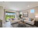 Spacious living room with sectional sofa and sliding glass doors leading to a patio at 20249 Symphony Pl, Venice, FL 34293