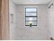 Updated bathroom with marble tile and a window at 2139 Abby Ave, Spring Hill, FL 34609