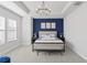 Spacious main bedroom with a blue accent wall, king-size bed and a sitting area at 2511 N Grady Ave # 26, Tampa, FL 33607