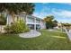 Landscaped backyard with circular patio and house view at 2601 Bay Blvd, Indian Rocks Beach, FL 33785