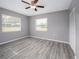 Spacious bedroom with two windows, wood-look floors, and ceiling fan at 34027 Saint Joe Rd, Dade City, FL 33525