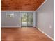 Bedroom with wood-look flooring, sliding glass door to deck, and wood ceiling at 34027 Saint Joe Rd, Dade City, FL 33525