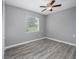 Bright bedroom with wood-look flooring, ceiling fan, and window at 34027 Saint Joe Rd, Dade City, FL 33525