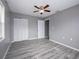 Bedroom featuring wood-look floors, a ceiling fan, and a closet at 34027 Saint Joe Rd, Dade City, FL 33525