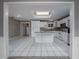 Bright kitchen with white cabinets, granite island, and tile floor at 34027 Saint Joe Rd, Dade City, FL 33525