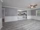 Open living room with view of kitchen, grey walls, and wood-look flooring at 34027 Saint Joe Rd, Dade City, FL 33525