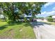 Ranch-style home with carport, mature landscaping, and spacious driveway at 604 Danube Ave, Tampa, FL 33606