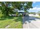 Ranch-style home with carport, mature landscaping, and spacious driveway at 604 Danube Ave, Tampa, FL 33606