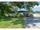 Ranch-style home with carport, mature landscaping, and spacious driveway at 604 Danube Ave, Tampa, FL 33606