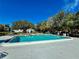 Inviting community pool with surrounding trees at 8651 10Th N St # 130, St Petersburg, FL 33702