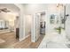 Bathroom with a double vanity, walk-in closet, and wood flooring at 8703 Cypress Mill Ct, Tampa, FL 33647