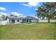 Large backyard with a pool, solar panels, and lush green lawn at 10618 Foxcrest Way, Riverview, FL 33569