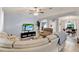 Living room with sectional sofa, large TV, ceiling fan and hardwood floors at 10618 Foxcrest Way, Riverview, FL 33569